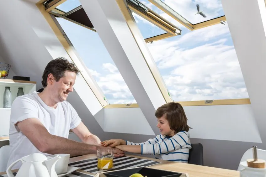 ojciec i syn na poddaszu z energooszczędnymi oknami dachowymi Fakro z pakietem trzyszybowym